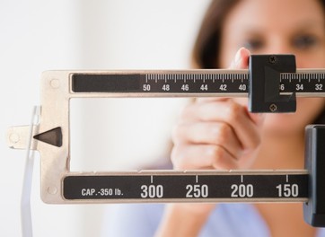 Cape Verdean woman weighing herself